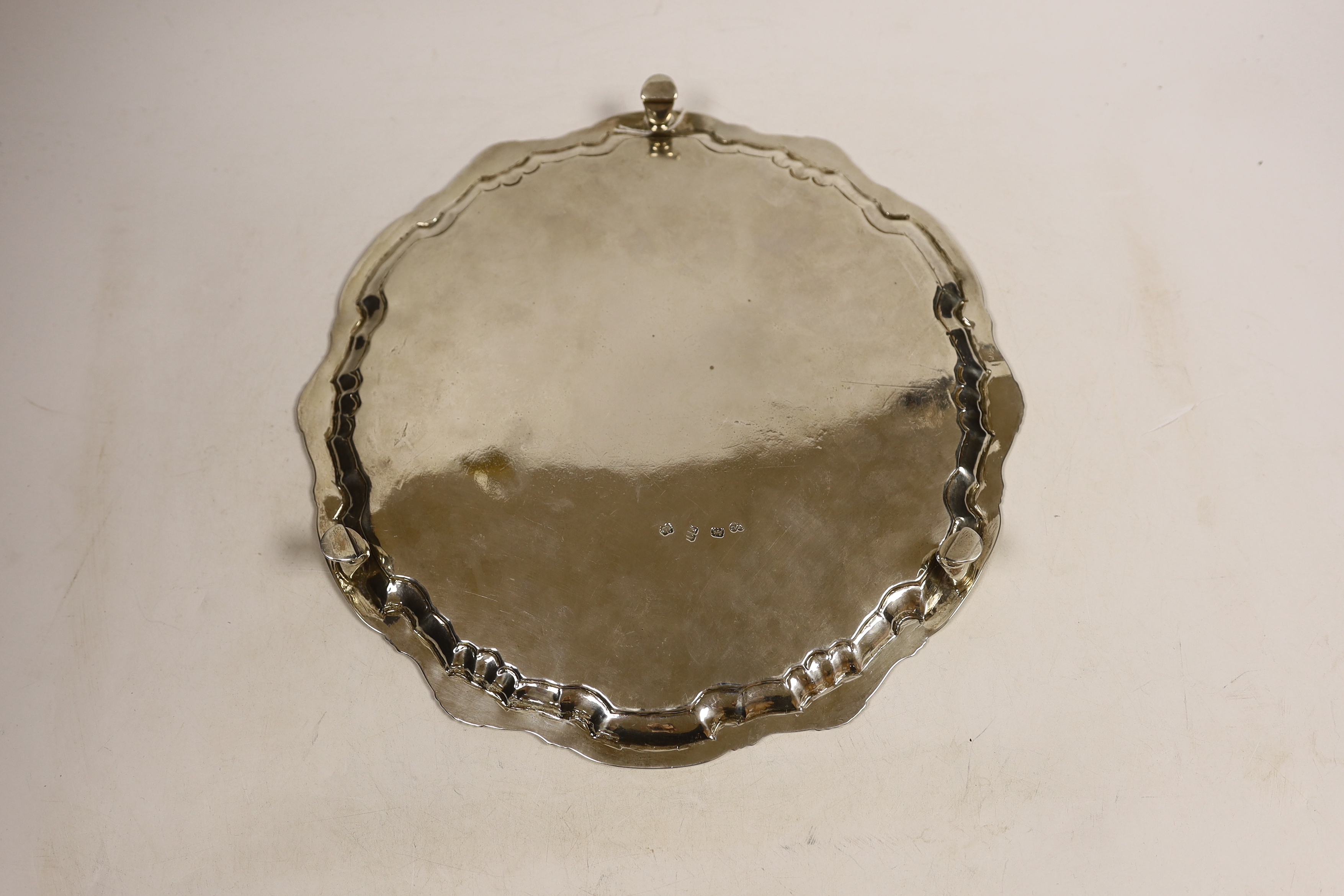 A George II silver salver, of shaped circular form, with shell and scroll border and engraved armorial, on three hoof feet, William Peaston, London, 1747, diameter 29.4cm, 27.2oz.